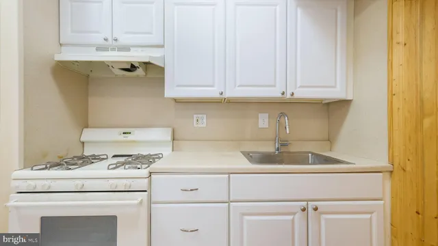 a kitchen with cabinets appliances a sink and a window