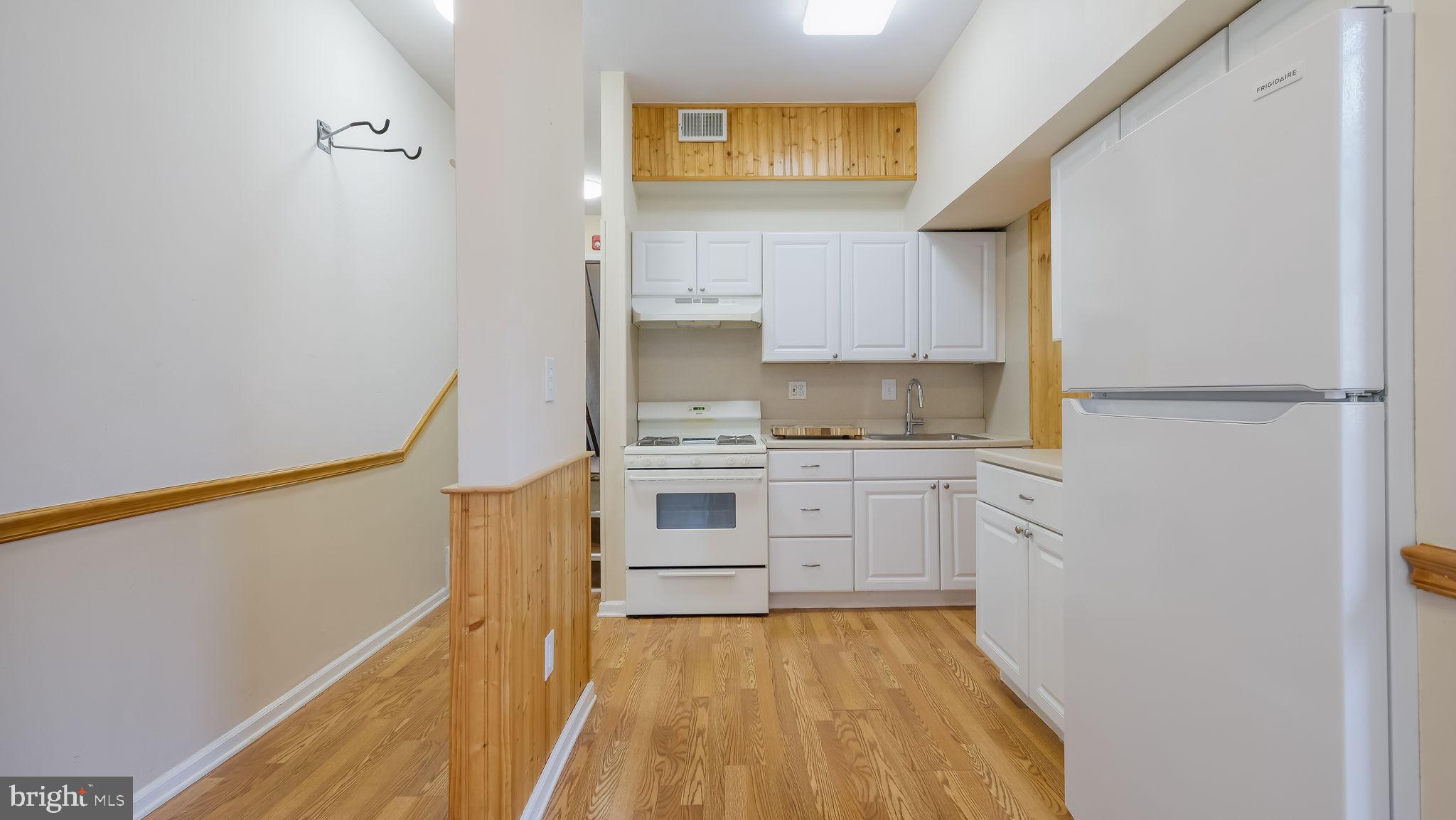 2120 South Street, Unit 2RE Philadelphia, PA 19146 - Photo 6 of 20 a kitchen with granite countertop white cabinets and white appliances