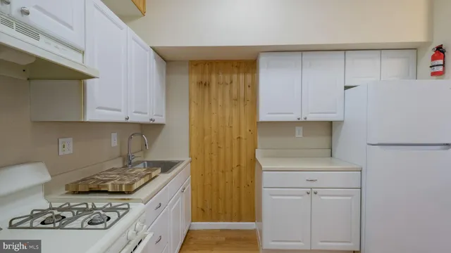 a kitchen with granite countertop white cabinets and white appliances
