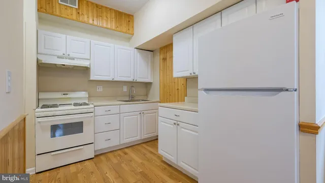 a view of a kitchen with wooden floor and a window