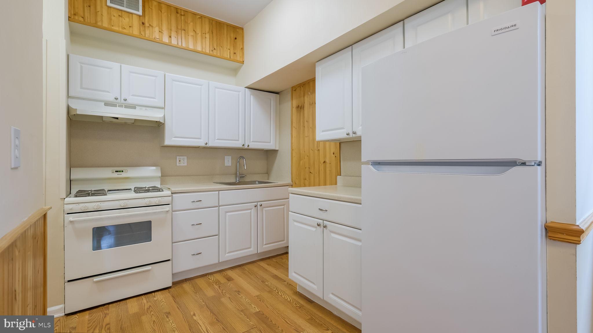 2120 South Street, Unit 2RE Philadelphia, PA 19146 - Photo 8 of 20 a kitchen with granite countertop white cabinets and white appliances