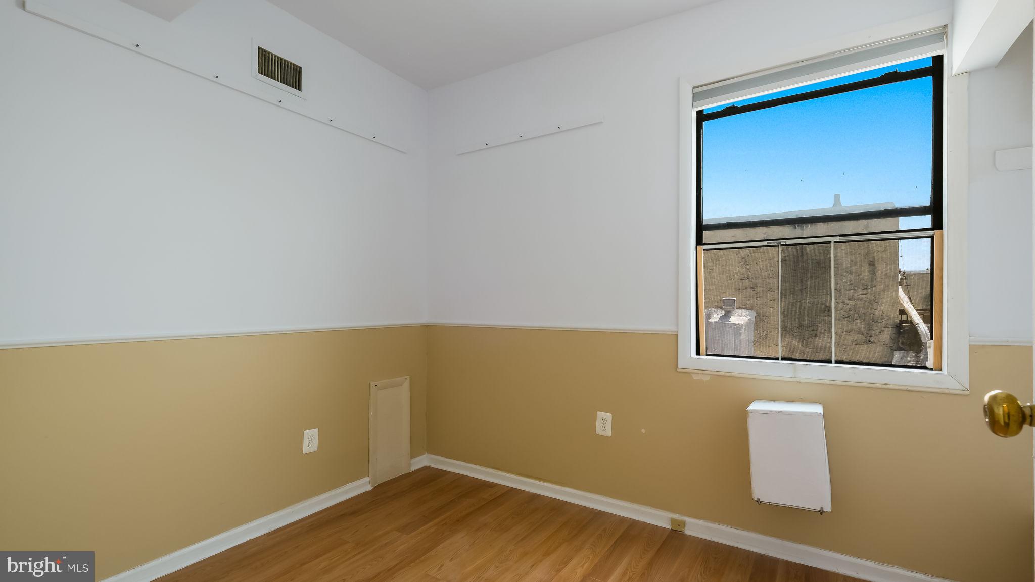 2120 South Street, Unit 2RE Philadelphia, PA 19146 - Photo 10 of 20 a view of an empty room with wooden floor and a window