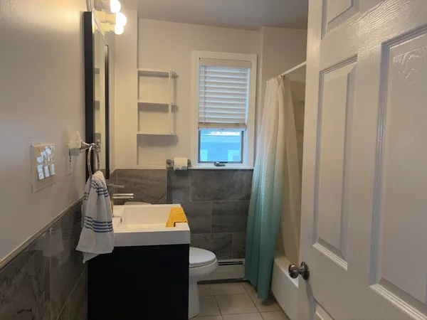 a bathroom with a toilet a sink and mirror
