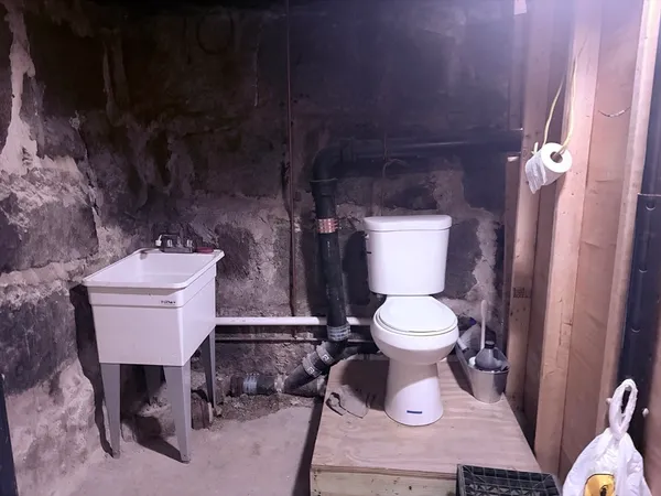 a bathroom with a toilet a sink and mirror