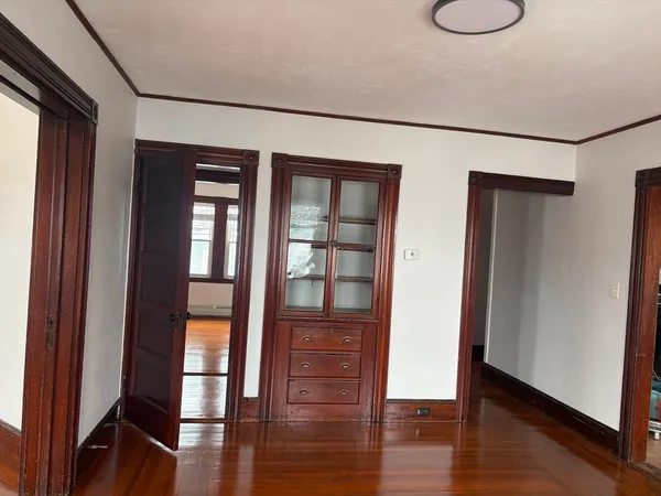 a view of empty room with wooden floor and fan