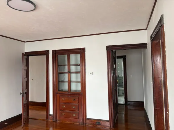 a view of a hallway with wooden floor and closet