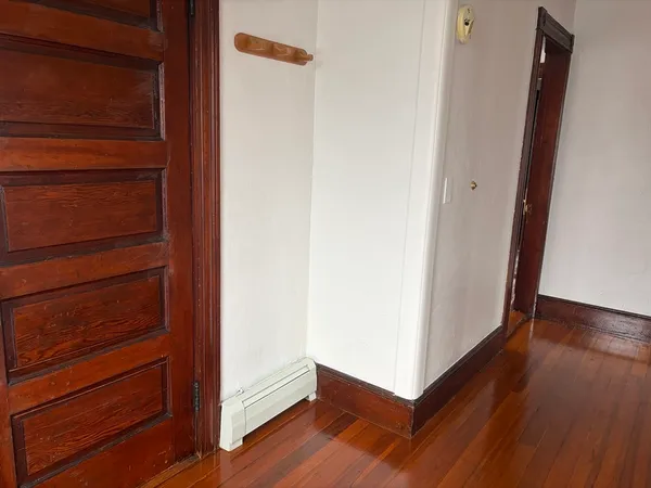 a view of a hallway with wooden floor
