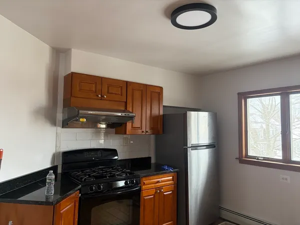 a kitchen with stainless steel appliances granite countertop a refrigerator a stove a sink and a microwave