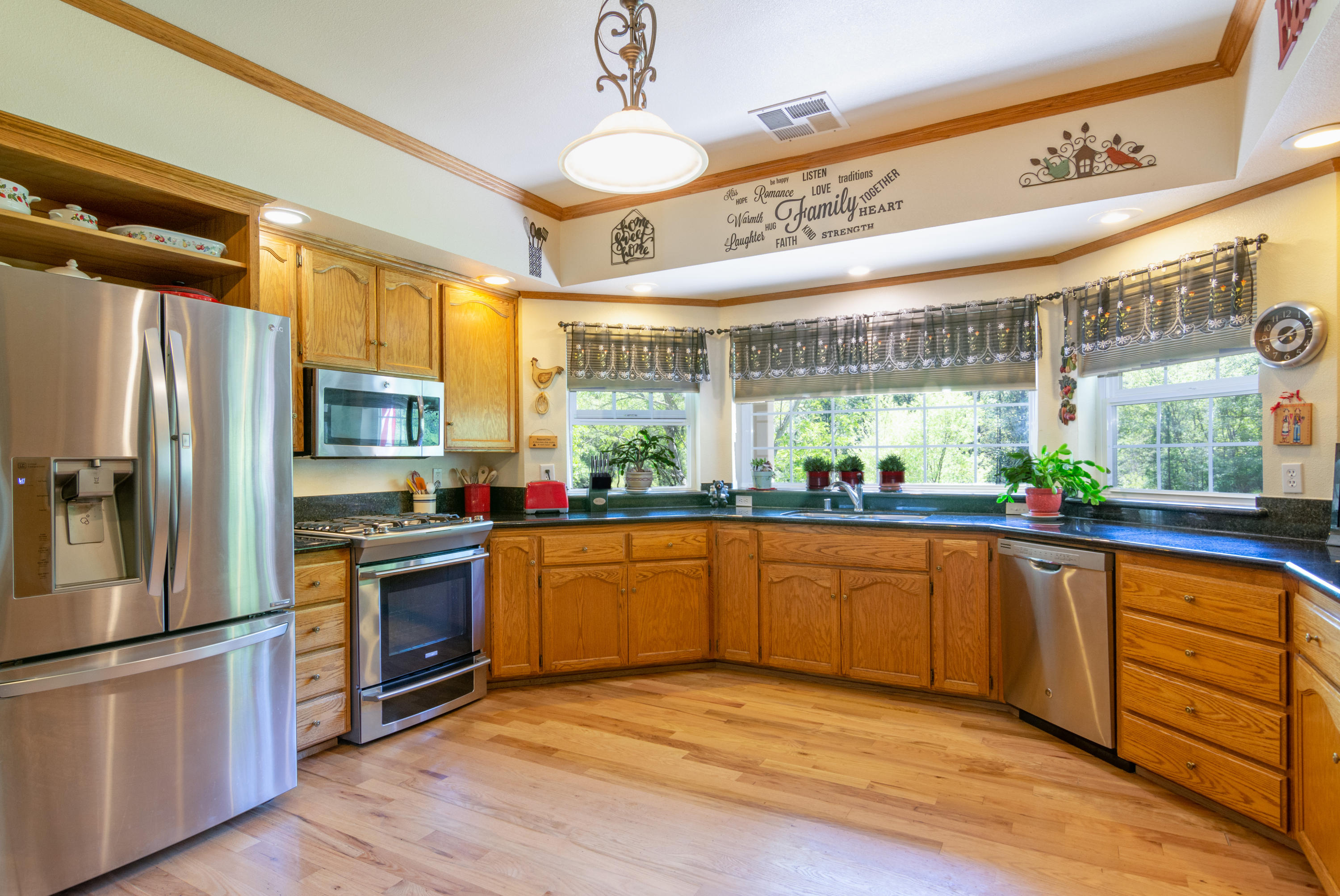 320 Salt Flat Road Lewiston, CA 96052 - Photo 7 of 32 a kitchen with stainless steel appliances granite countertop a refrigerator a sink dishwasher a stove and white countertops with wooden floor