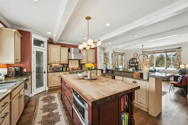 a kitchen with a stove center island cabinets and wooden floor