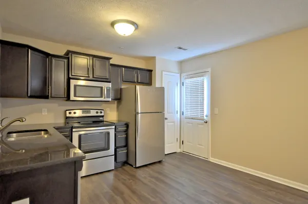 a kitchen with stainless steel appliances granite countertop a refrigerator stove and sink
