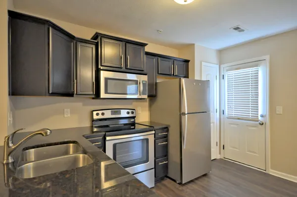 a kitchen with stainless steel appliances a refrigerator sink and microwave