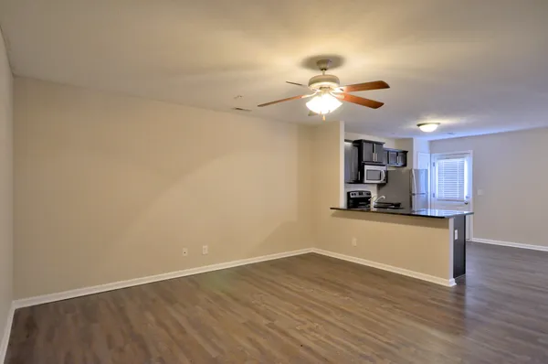 a view of a kitchen with wooden floor and a ceiling fan