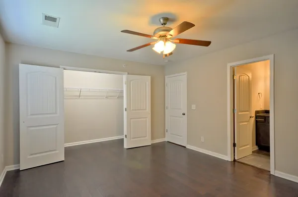an empty room with closet and a chandelier fan