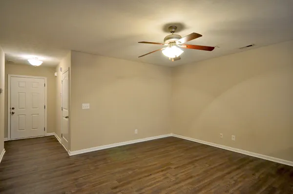 a view of an empty room with wooden floor