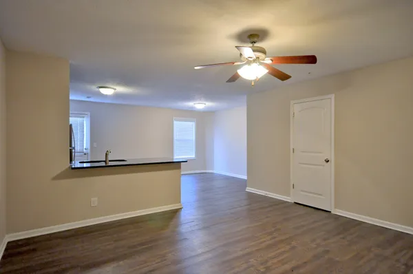a view of a kitchen with wooden floor and a ceiling fan