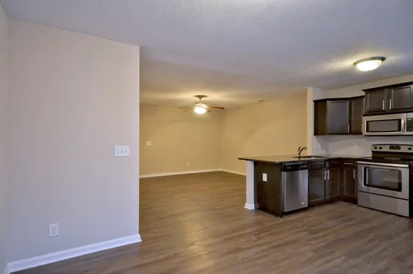 a view of kitchen with stainless steel appliances granite countertop cabinets and wooden floor