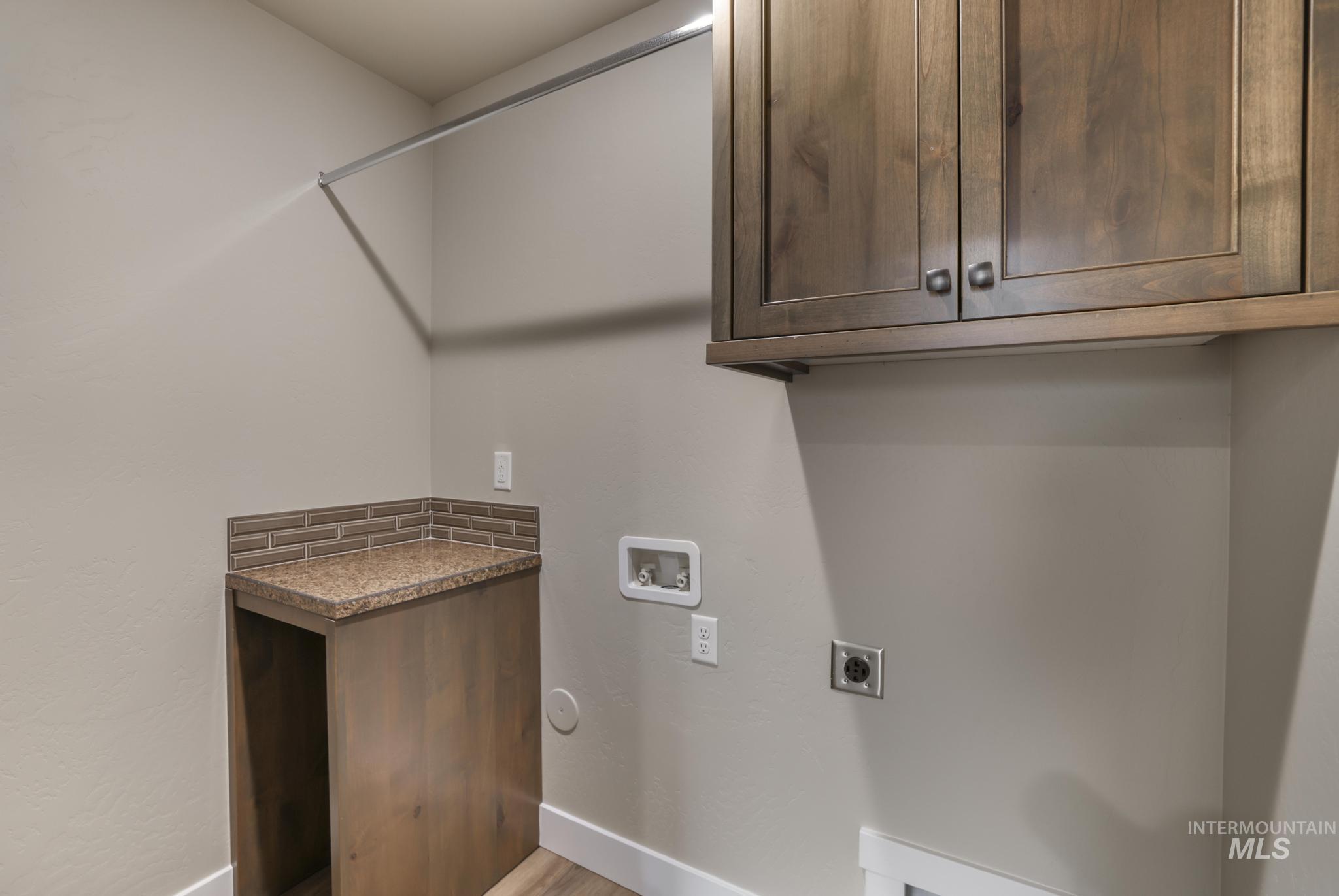 812 Jack Avenue Jerome, ID 83338 - Photo 13 of 38 Laundry area featuring cabinet space, hookup for an electric dryer, washer hookup, and light wood finished floors