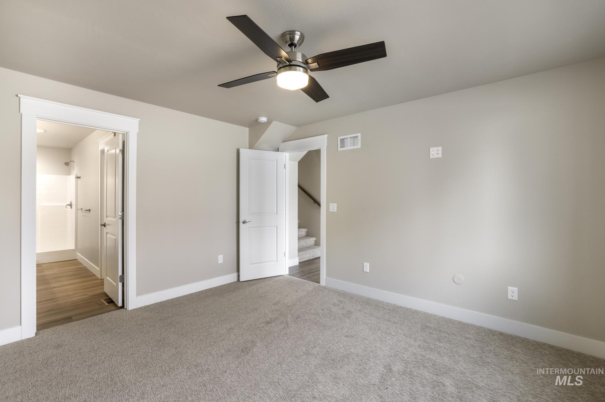 812 Jack Avenue Jerome, ID 83338 - Photo 15 of 38 Unfurnished bedroom with connected bathroom, carpet, and a ceiling fan