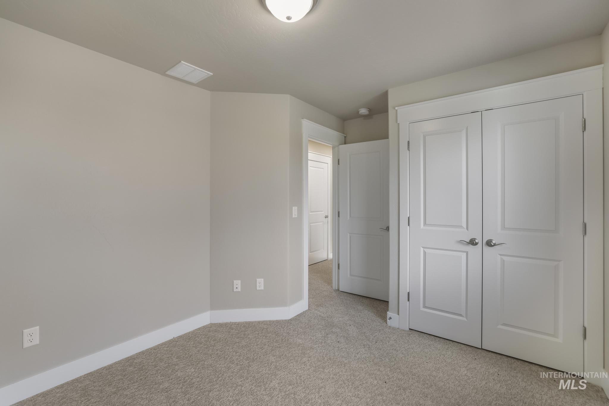 812 Jack Avenue Jerome, ID 83338 - Photo 21 of 38 Unfurnished bedroom featuring light carpet and a closet