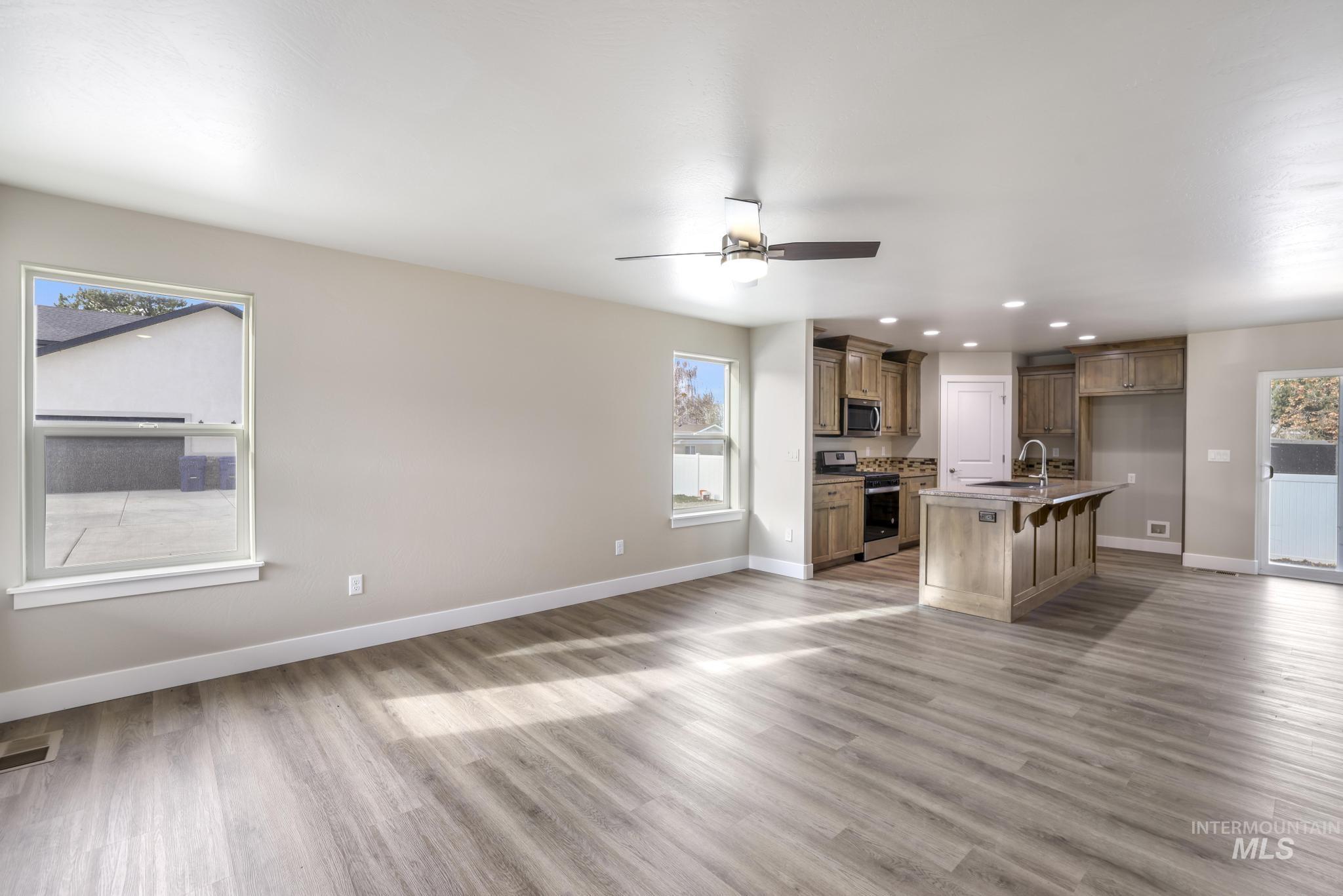 812 Jack Avenue Jerome, ID 83338 - Photo 37 of 38 Kitchen featuring a breakfast bar area, open floor plan, appliances with stainless steel finishes, a kitchen island with sink, and recessed lighting