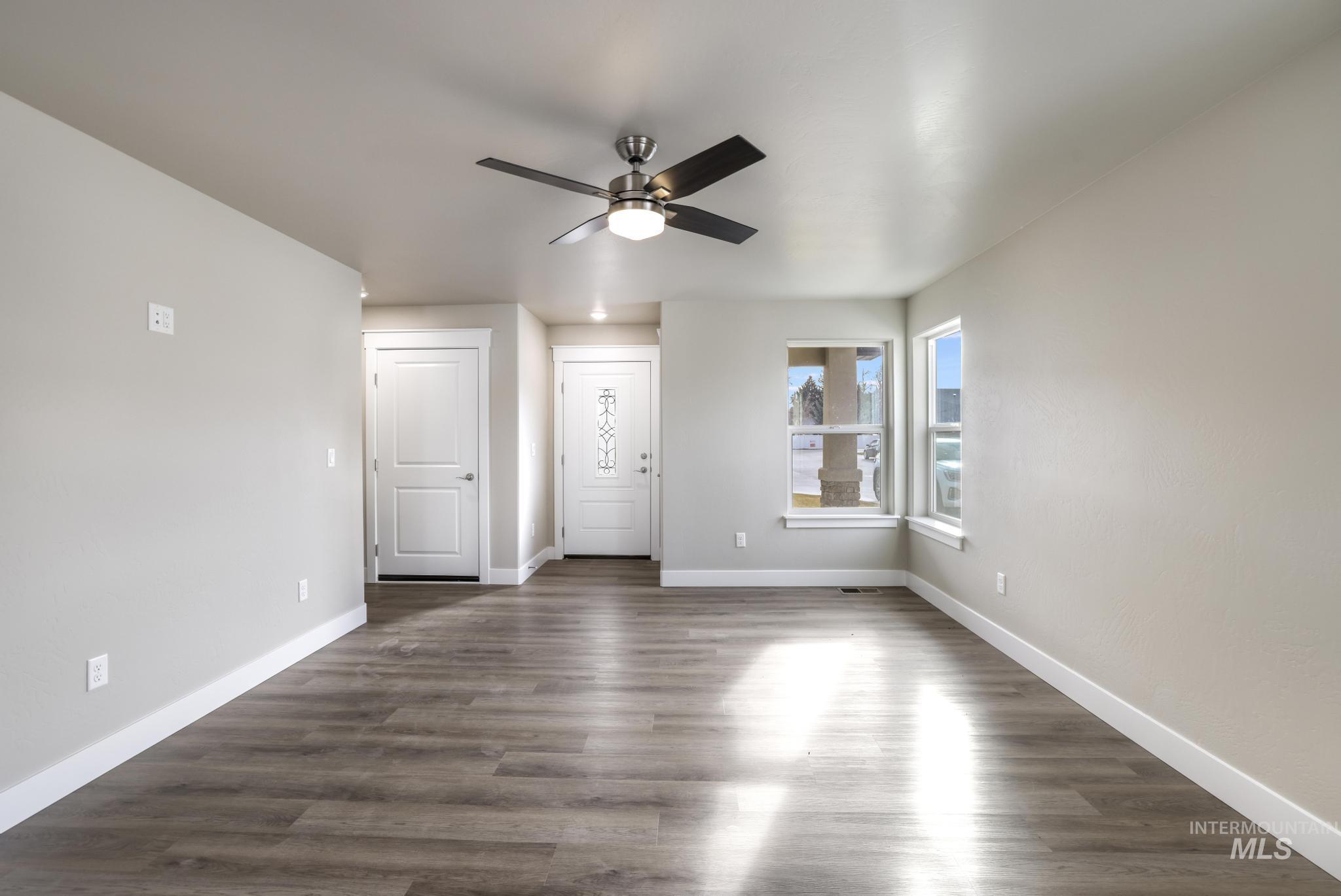 812 Jack Avenue Jerome, ID 83338 - Photo 5 of 38 Unfurnished living room with dark wood-type flooring and a ceiling fan