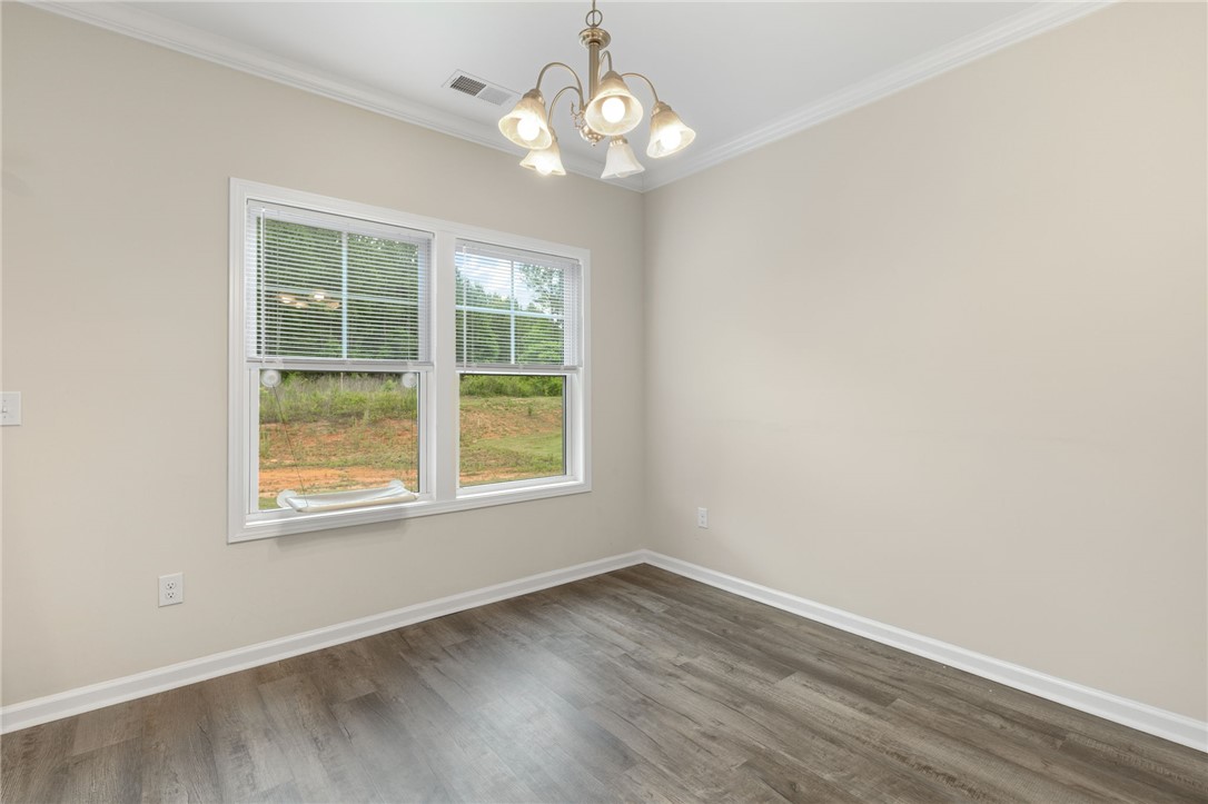 122 Bellflower Lane Anderson, SC 29625 - Photo 6 of 15 This bright room features beautiful flooring and a classic chandelier, offering a perfect canvas for personalization.