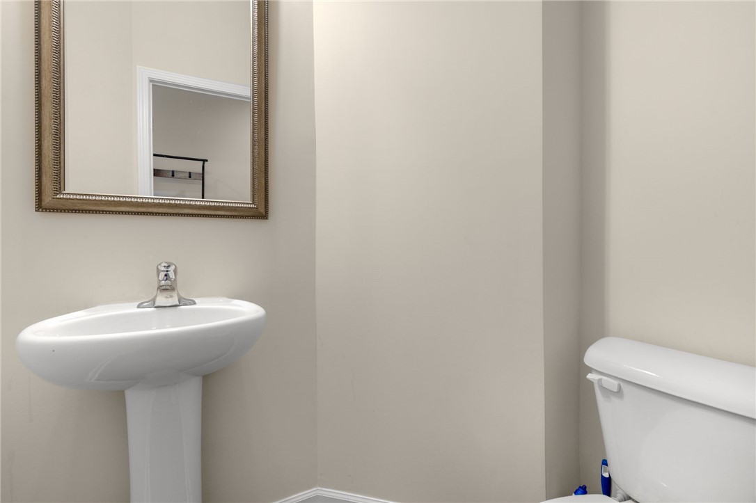 122 Bellflower Lane Anderson, SC 29625 - Photo 7 of 15 This clean and bright powder room features a classic pedestal sink and toilet, reflecting light from a mirror.