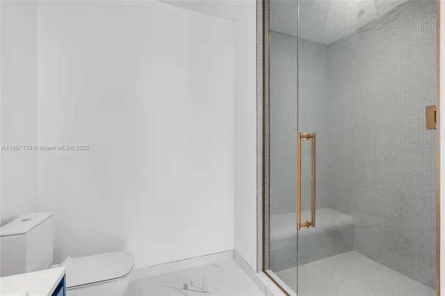 a bathroom with a granite countertop toilet and a shower