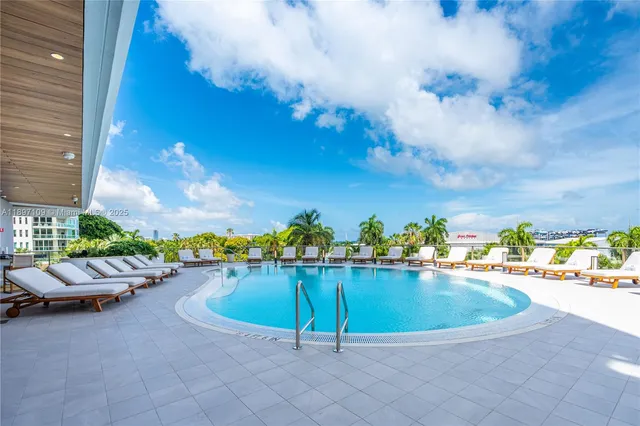 a front view of a building with a swimming pool and outdoor seating
