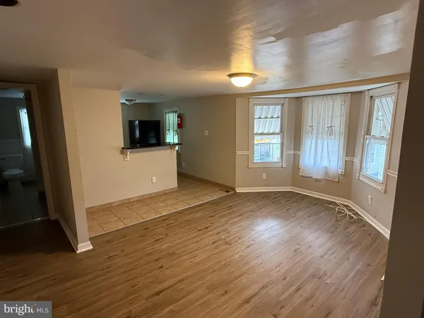 an empty room with wooden floor and a window