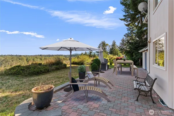a view of a patio with a table and chairs under an umbrella