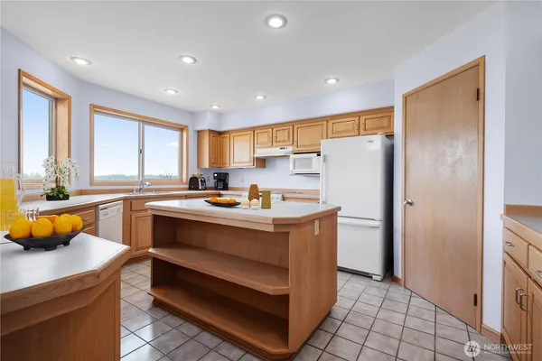 a kitchen with stainless steel appliances granite countertop a refrigerator a sink and a stove