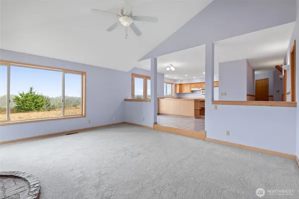 an empty room with a kitchen and windows