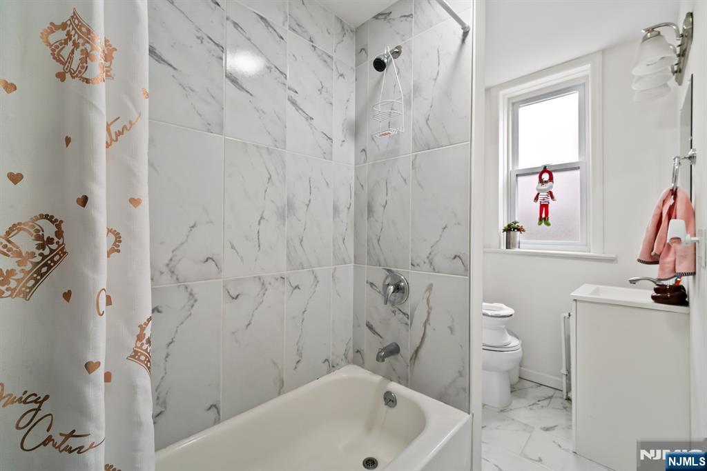 94 Center Street Clifton, NJ 07011 - Photo 14 of 38 a bathroom with a sink a toilet and shower