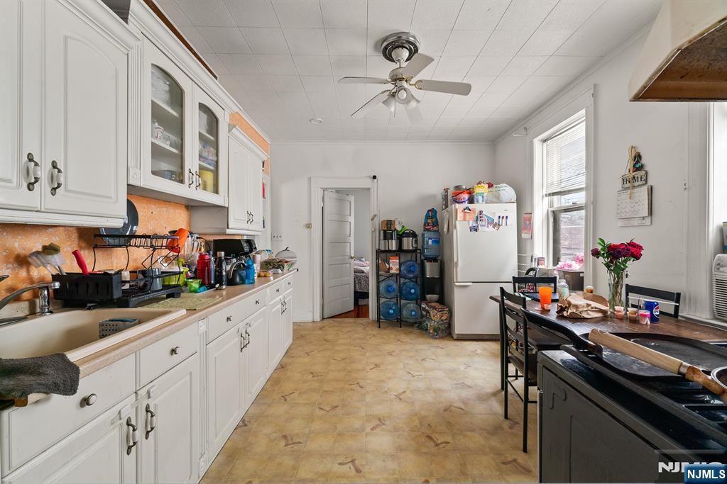 94 Center Street Clifton, NJ 07011 - Photo 20 of 38 a kitchen that has a lot of cabinets stainless steel appliances and a counter top space