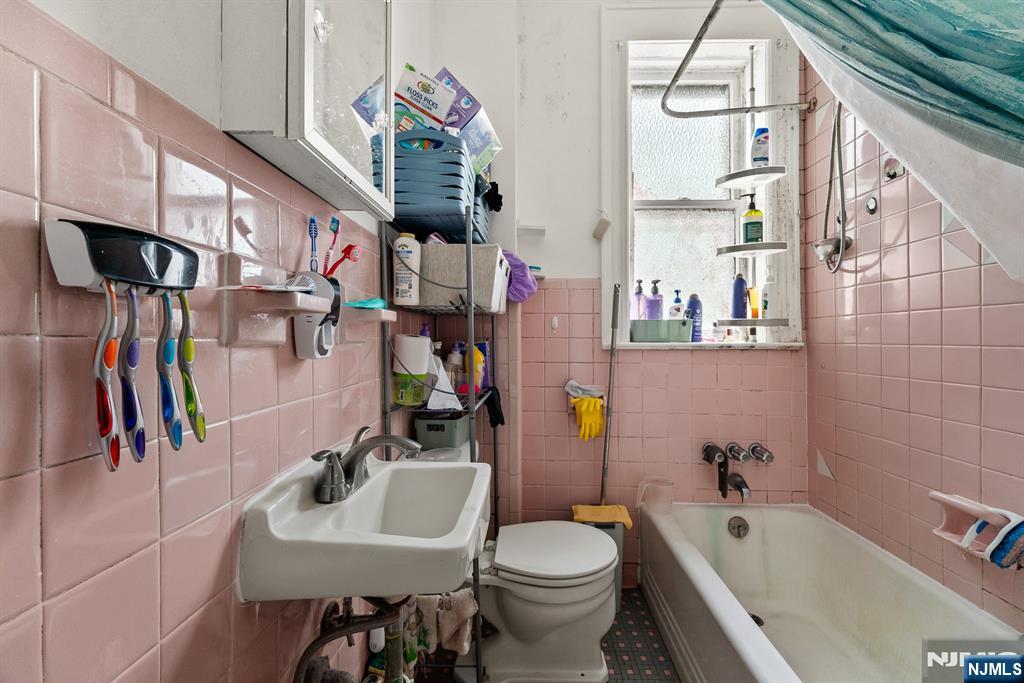 94 Center Street Clifton, NJ 07011 - Photo 21 of 38 a bathroom with a sink a toilet and shower