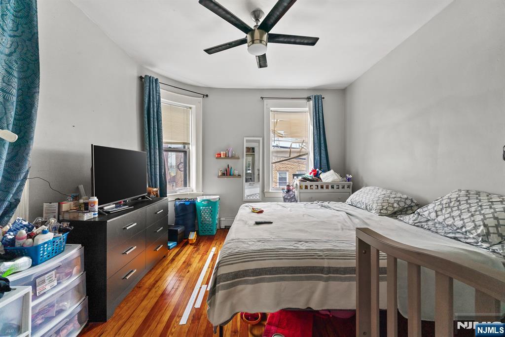 94 Center Street Clifton, NJ 07011 - Photo 23 of 38 a bedroom with a bed and a flat screen tv