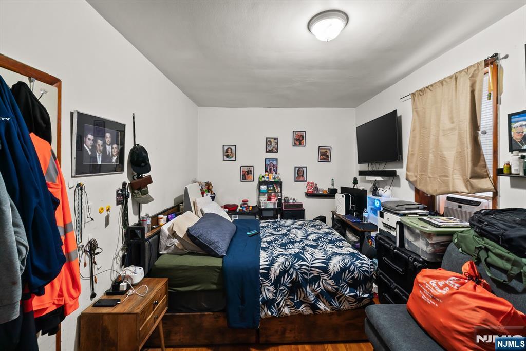 94 Center Street Clifton, NJ 07011 - Photo 4 of 38 a bed room with furniture and a flat screen tv
