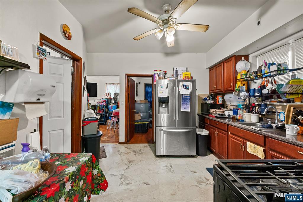 94 Center Street Clifton, NJ 07011 - Photo 7 of 38 a storage room with stainless steel appliances kitchen island granite countertop lots of clutter