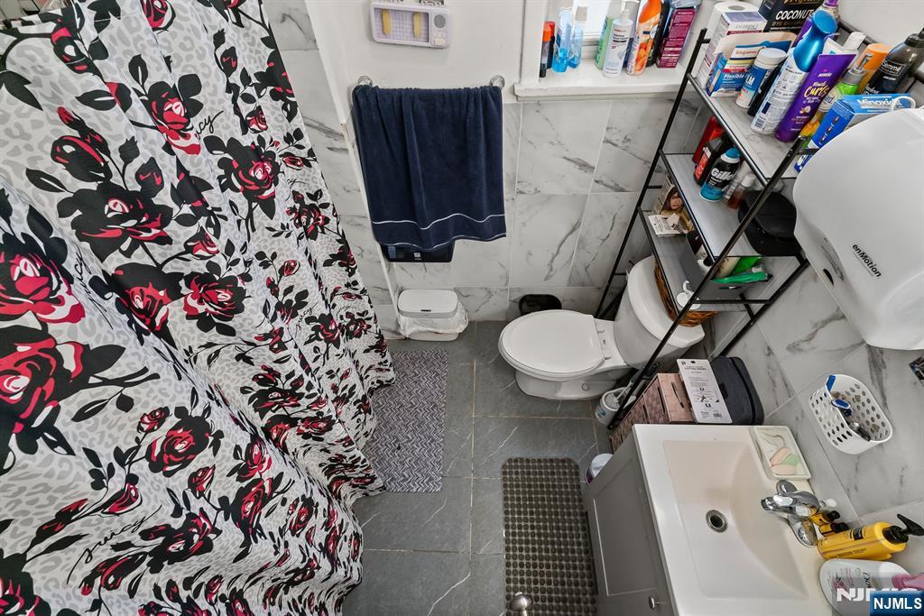 94 Center Street Clifton, NJ 07011 - Photo 8 of 38 a bathroom with a sink and toilet