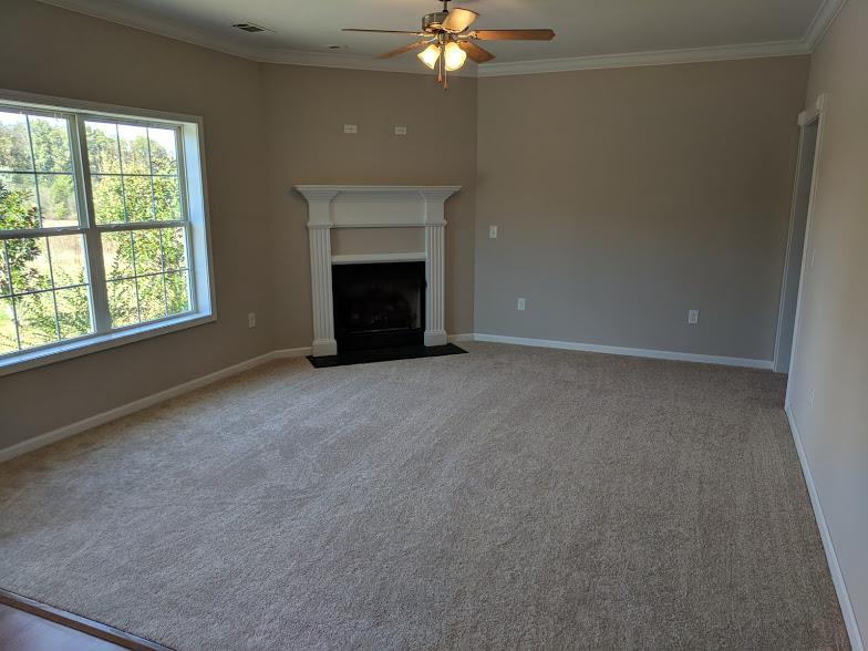 263 Elora Road Elora, TN 37328 - Photo 6 of 16 an empty room with a fireplace and fan