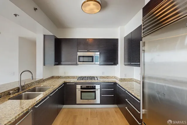 a kitchen with granite countertop a sink and stainless steel appliances