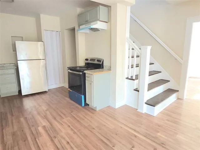 a view of a kitchen with wooden floor and electronic appliances