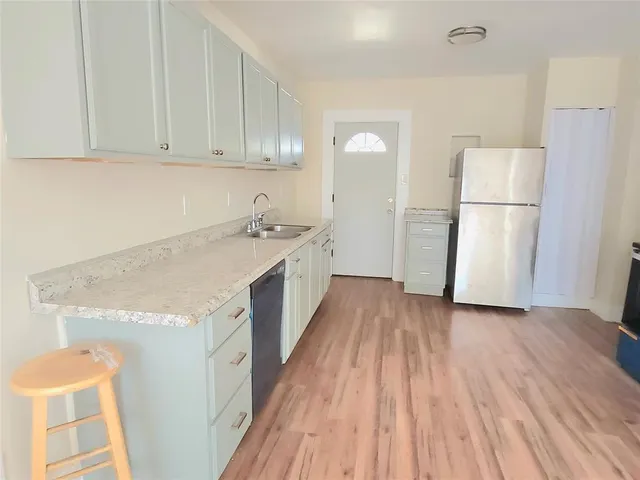 a kitchen with a sink a refrigerator a microwave and cabinets