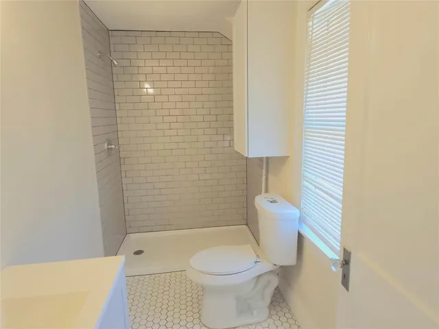 a bathroom with a toilet and a shower