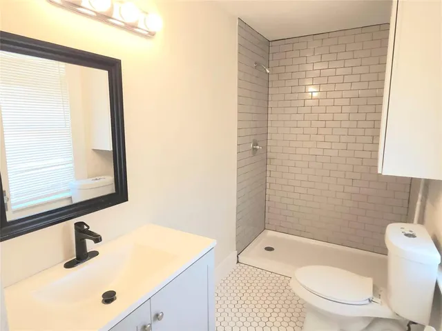 a bathroom with a sink toilet and shower