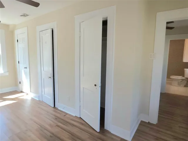 a view of a hallway with wooden floor