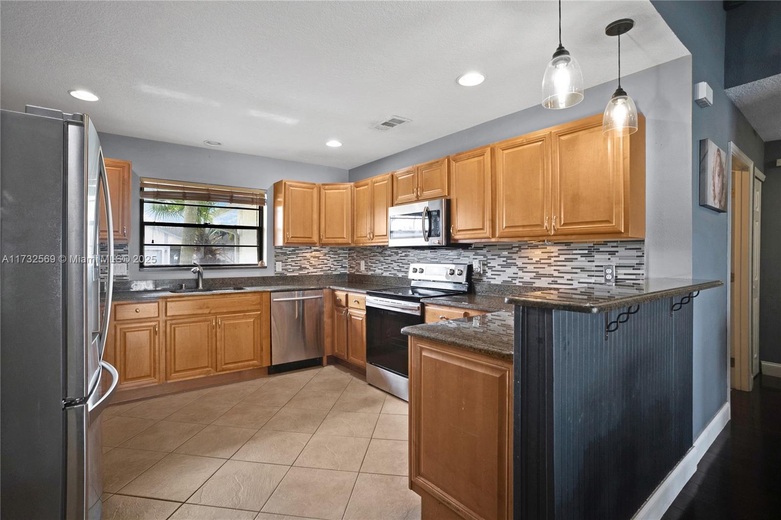 9635 Triton Court Boca Raton, FL 33434 - Photo 7 of 18 a kitchen with stainless steel appliances granite countertop a refrigerator and a stove top oven