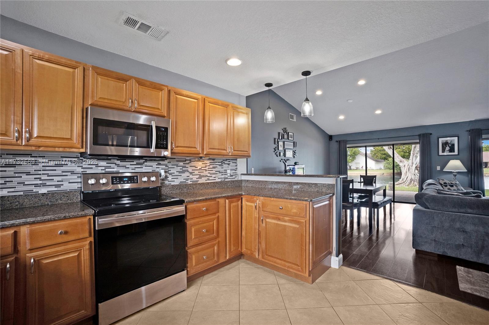 9635 Triton Court Boca Raton, FL 33434 - Photo 8 of 18 a kitchen with stainless steel appliances granite countertop wooden cabinets a stove top oven a sink and dishwasher